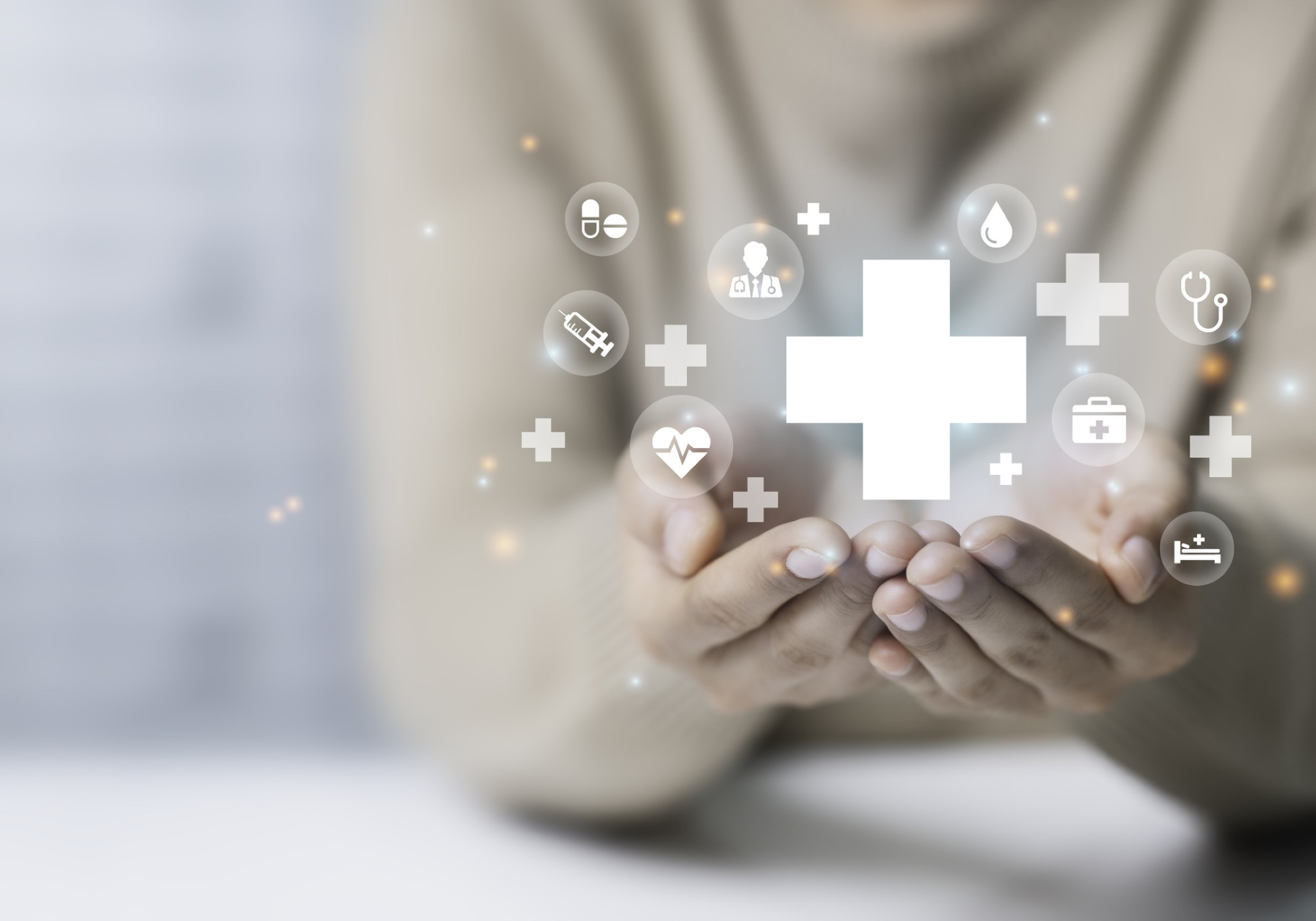 Hands holding healthcare icons and symbols.